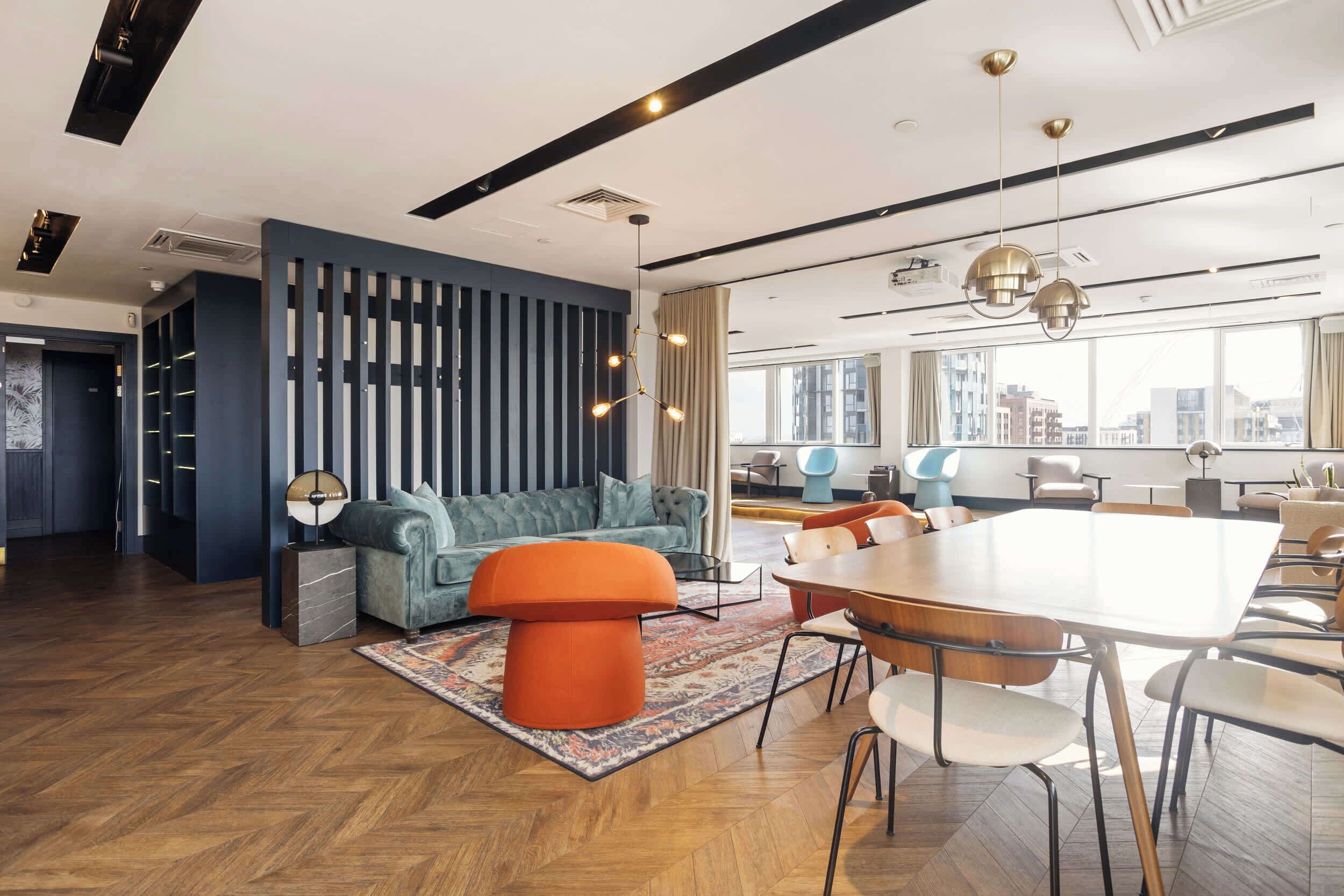 A modern interior with a seating area, a dining table, and a large window offering a city view.