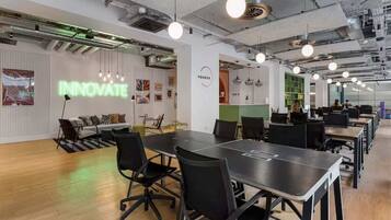An office space with a large conference table, black office chairs, and a 'VONDER INNOVATE' sign on the wall.