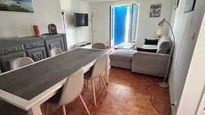 Um espaço de estar compacto com área de jantar, sofá e televisão.