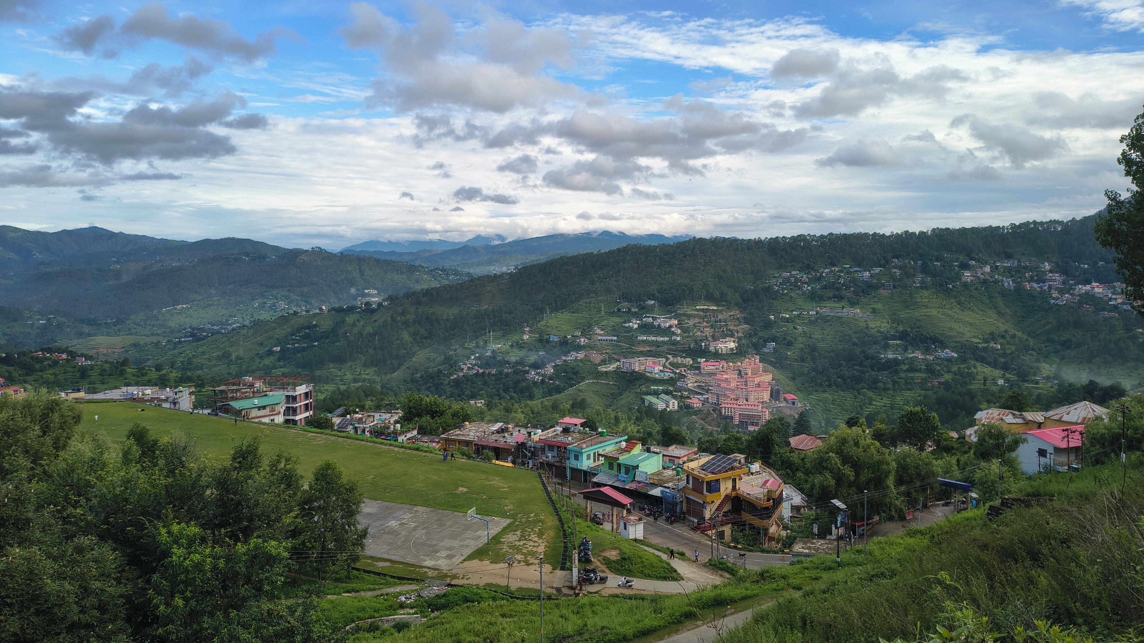 A mountainous landscape with a village, terraced fields, and a variety of buildings.