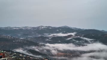 A mountainous landscape with terraced fields and a village at the base.