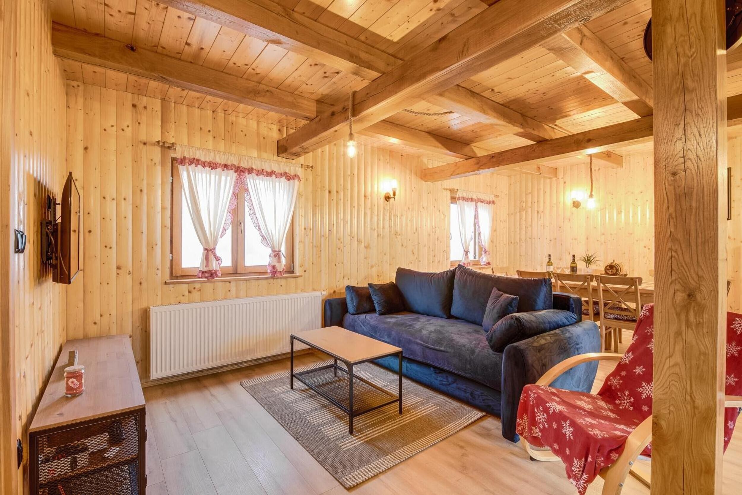 Un accogliente interno in legno con un divano, un tavolino e un termosifone.