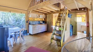 A wooden interior with a kitchen, dining area, and a staircase. - La Vie Joyeuse Lodge (Vigeois)