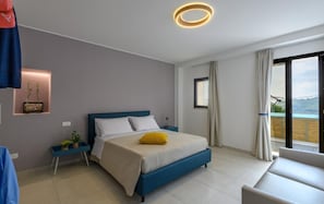 Une chambre à coucher moderne, avec un lit, des tables de chevet, une vue sur l’extérieur et un luminaire au plafond.