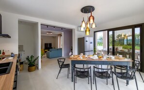 A modern kitchen with a dining area, a refrigerator, and a large window. - Welcome to Villa Michè, an elegant, upscale villa located in Colonnella (Colonnella)