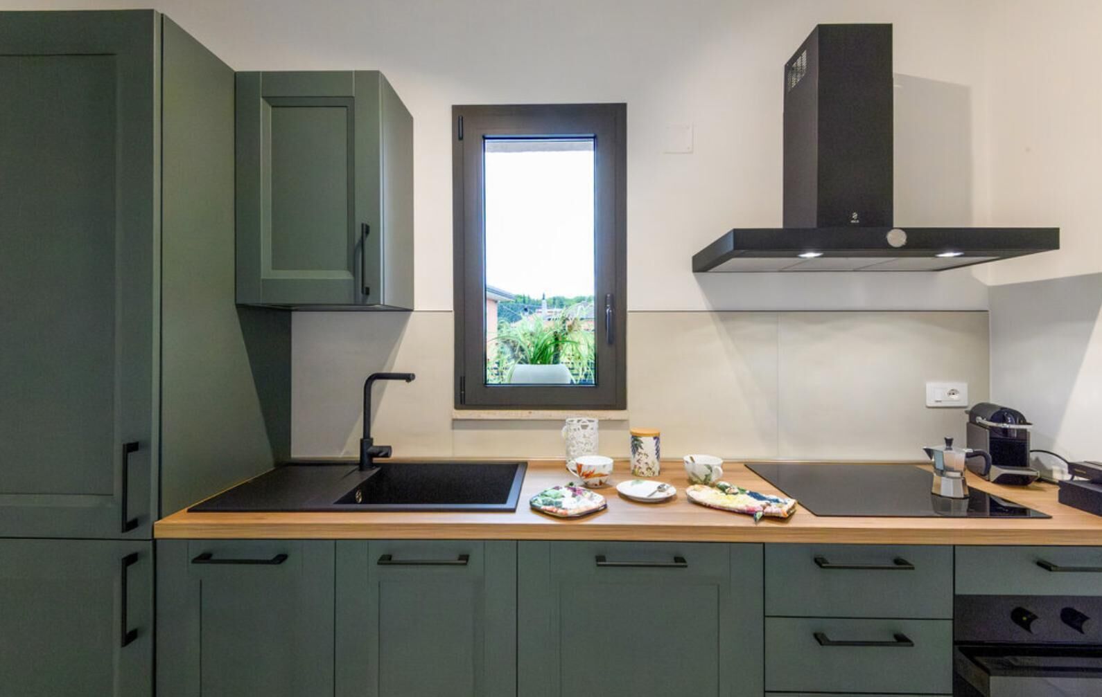 Een moderne keuken met een raam, een spoelbak en een fornuis.