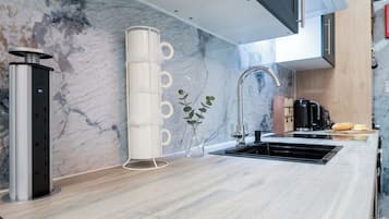 A modern kitchen with a marble backsplash, stainless steel appliances, and a minimalist design.