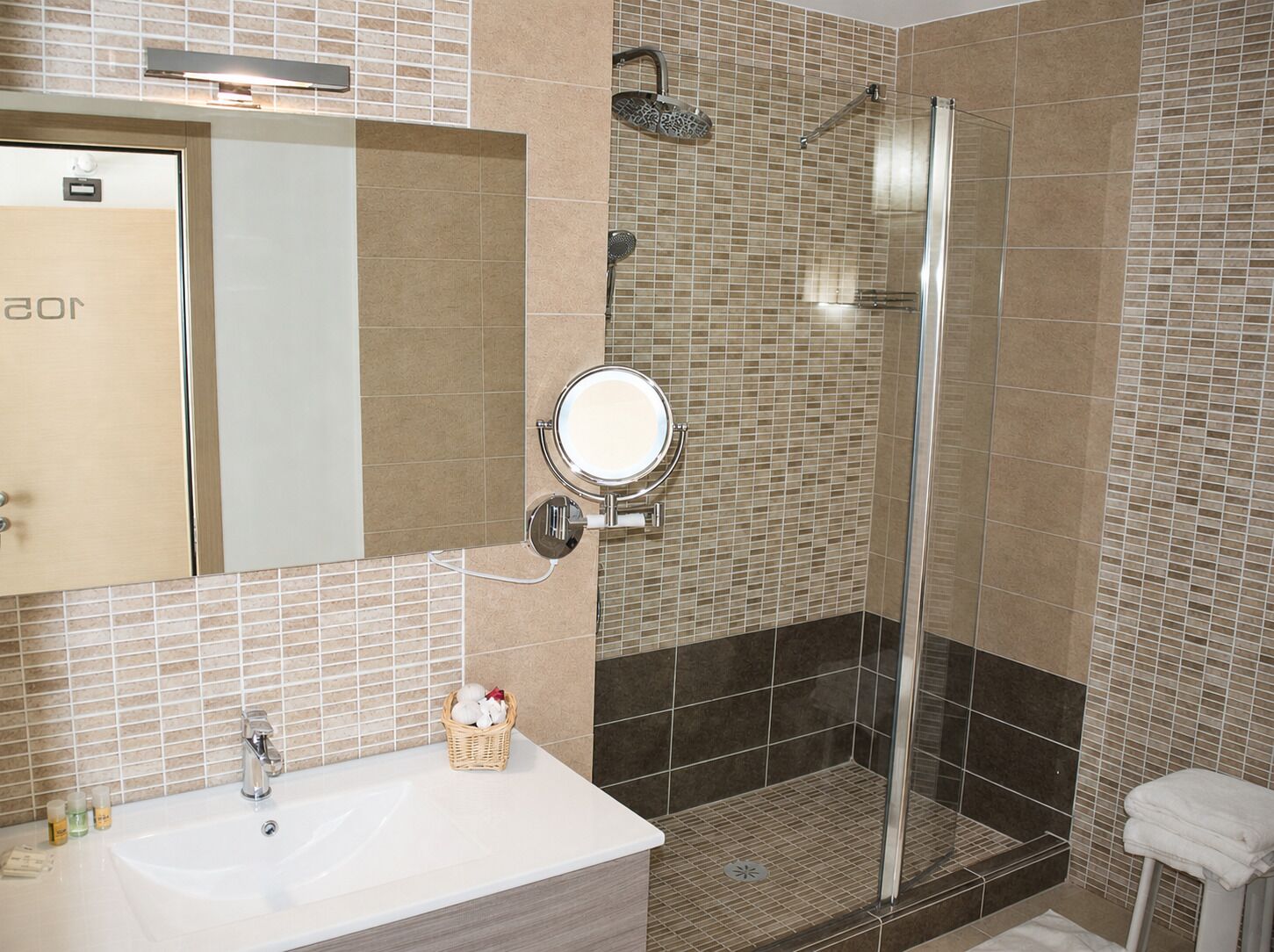 Un baño con ducha, lavabo y espejo.