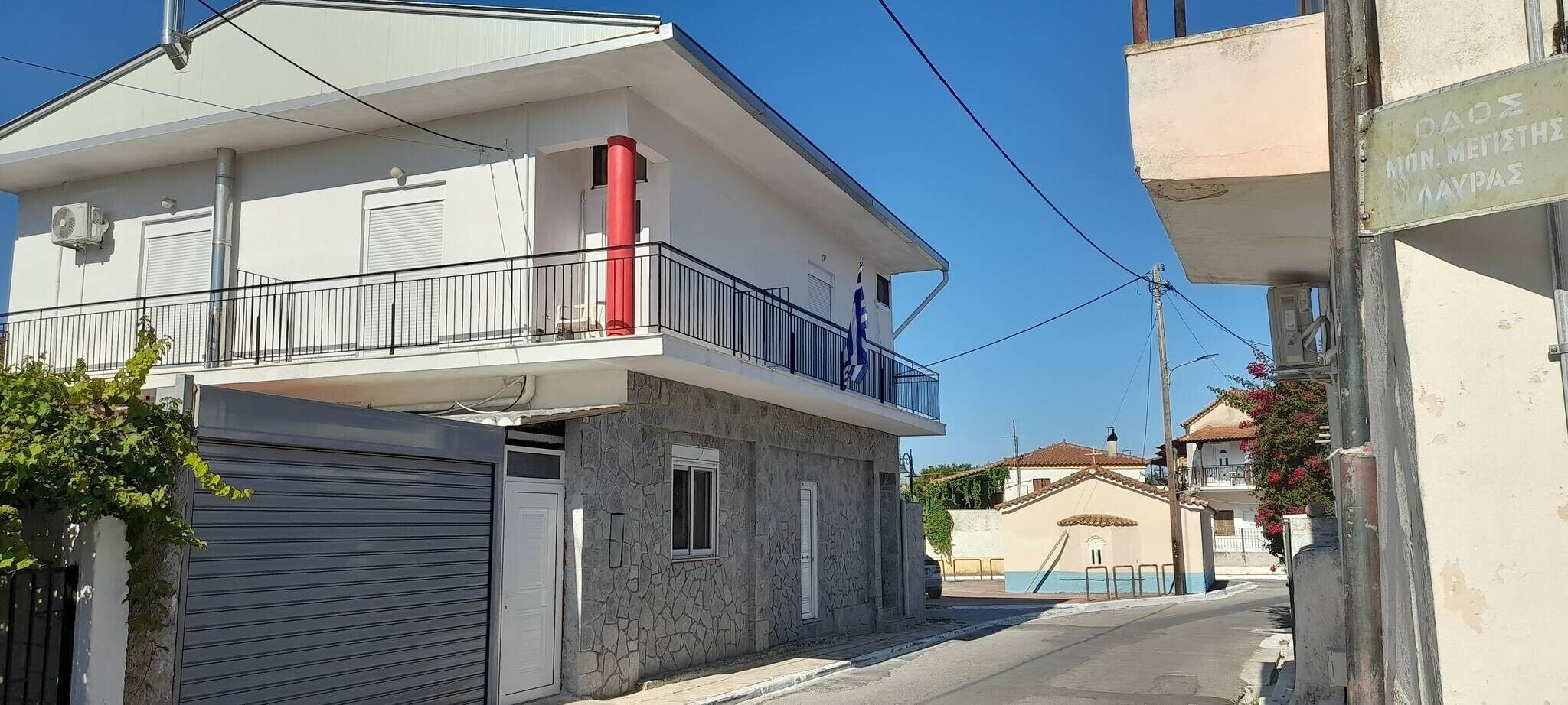 A residential building with a balcony, a garage, and a clear sky.