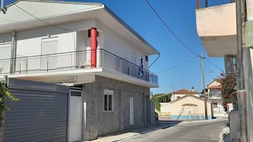 Un edificio residencial con balcón, garaje y cielo despejado.