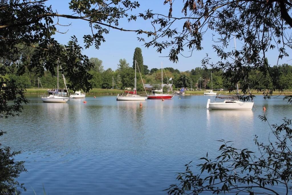 A calm lake with several boats anchored.