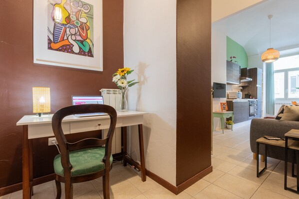 A modern living room with a dining area, a kitchen in the background, and a large abstract painting on the wall. - Casa Tropicana Ro-jo by Wonderful Italy (Turin)