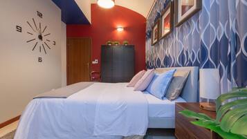 A bedroom with a bed, bedside tables, a clock, and a wardrobe.