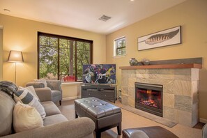 A living room with a fireplace, a television, and a couch.
