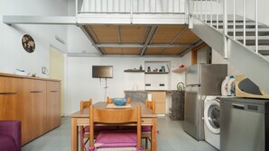 A compact kitchen with a dining area, a washing machine, and a staircase. - GuestHost - Comfy Apartment X5 California MM4 (Milan)
