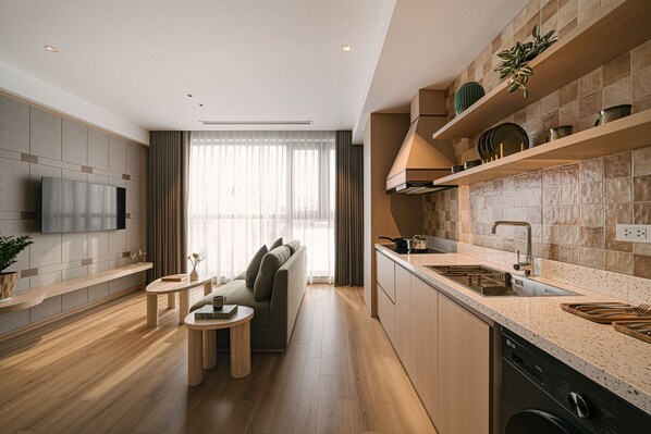 Une cuisine moderne avec des meubles en bois, un four encastré et un évier en acier inoxydable.