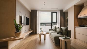 Un salon moderne avec un canapé, une table basse et un téléviseur fixé au mur.