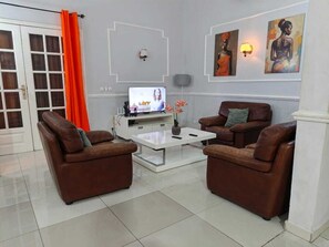 Ein Wohnzimmer mit zwei braunen Sofas, einem weißen Couchtisch und einem Fernseher.