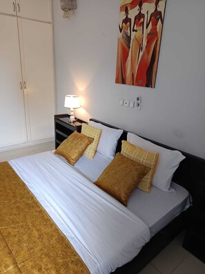 Una camera d'albergo con un letto, comodini, una lampada e un quadro appeso al muro.