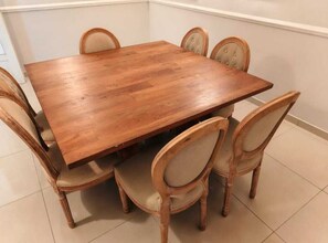 Ein Holzesstisch mit sechs Stühlen, jeweils mit gepolstertem Sitz und gebogener Rückenlehne.