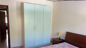 A bedroom with a bed, a wardrobe, a nightstand, and a lamp. - Feel right at home and enjoy a unique experience. (Penne)