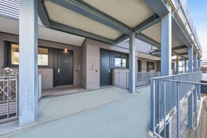 A modern building with a covered entrance, metal railings, and a flat roof. - Lunea Stay Apartment Hotel in Esslingen (Esslingen am Neckar-Mettingen)