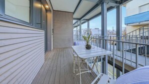 A balcony with a table and chairs, a potted plant, and a view of the cityscape. - Lunea Stay Apartment Hotel in Esslingen (Esslingen am Neckar-Mettingen)