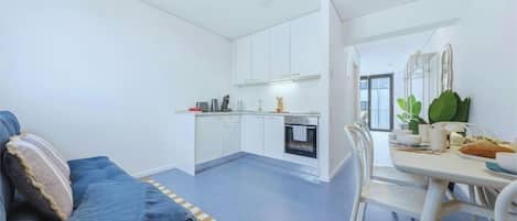 A compact living space with a kitchenette, a dining area, and a sofa.