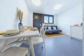 Un espacio habitable compacto con comedor, sofá y kitchenette.