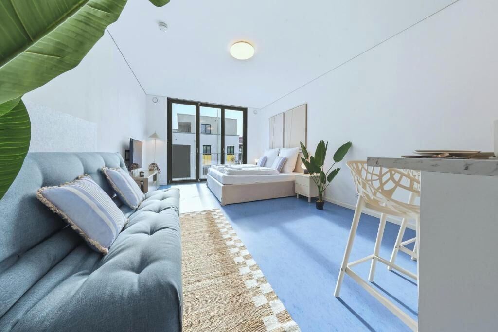 Ein modernes Wohnzimmer mit einer Couch, einem Couchtisch und einer Pflanze.