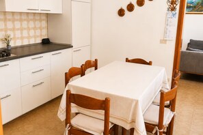 A dining area with a table set for six, surrounded by wooden chairs.