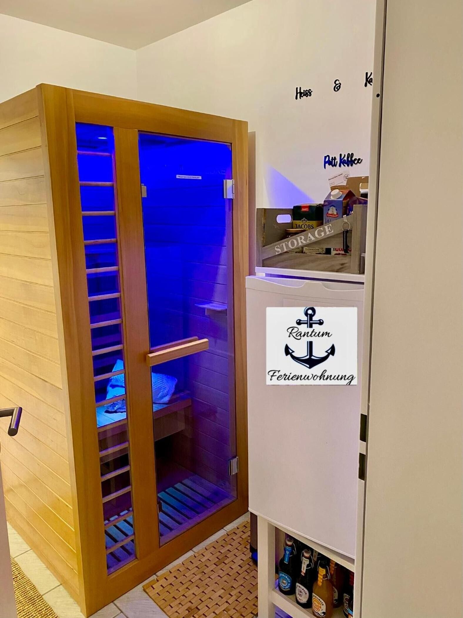 Ein Zimmer mit einem Holzschrank, einem blauen Schrank und einem Stauraum mit dem Schild 'Rantum Ferienwohnung'.