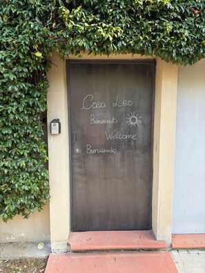 Eine Tür mit einer Kreidetafel, auf der 'Casa Leo' und 'Willkommen' steht.
