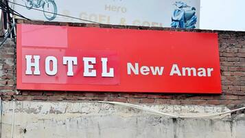 Un letrero rojo que dice 'HOTEL New Amar'.