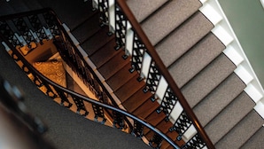 A spiral staircase with a handrail and carpeted steps. - 1 Bed Luxury Apartment at Rutland Square (Edinburgh)