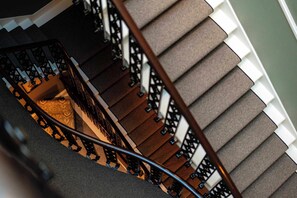 Eine Wendeltreppe mit Handlauf und Teppichstufen.