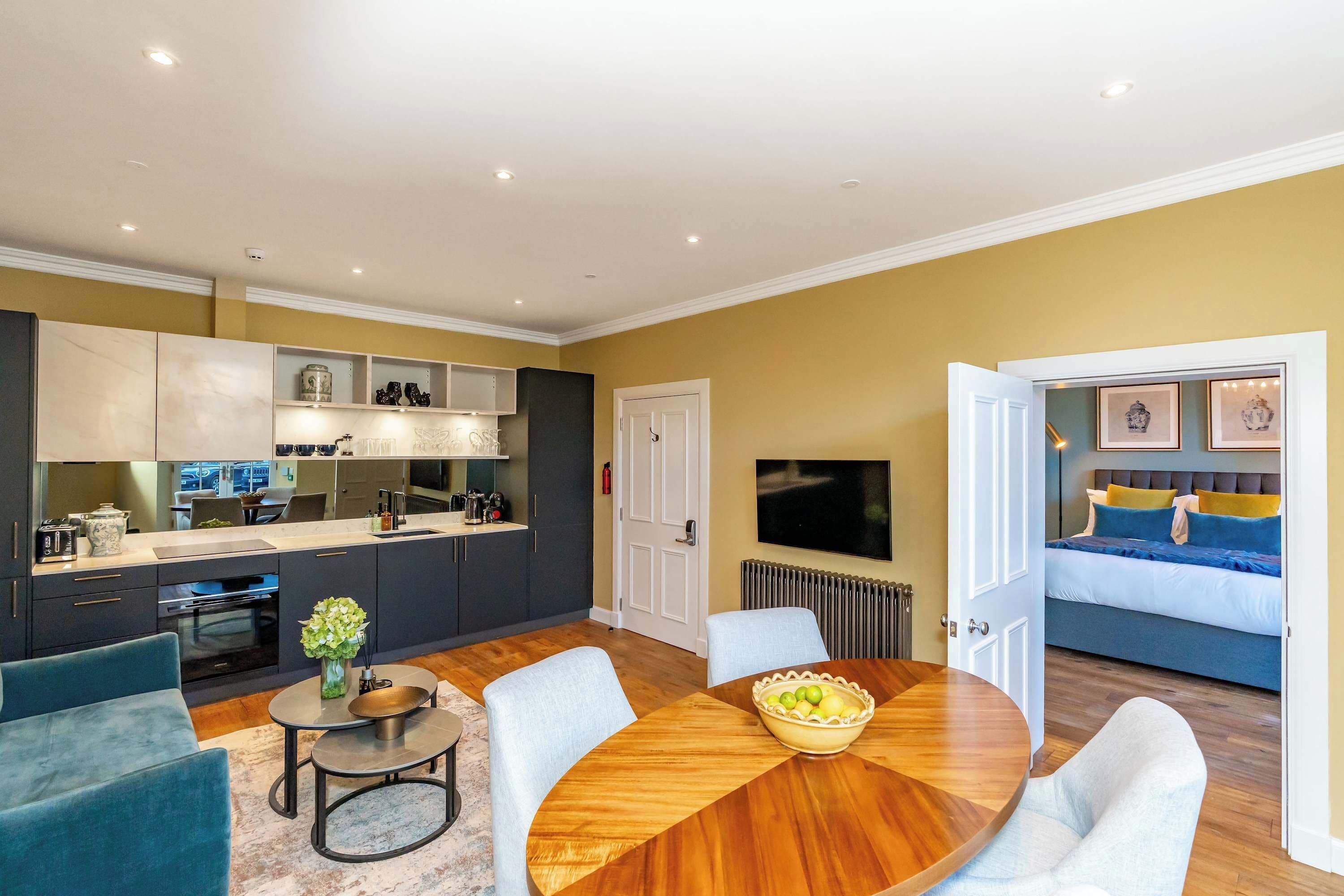A modern living space with a kitchen, dining area, and bedroom.