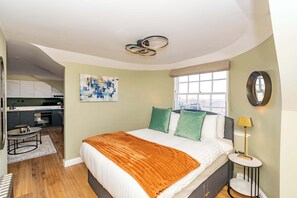 A modern bedroom with a bed, bedside table, and a view of the city. - Ponton Suite - 1 Bed Luxury Apartment (Edinburgh)