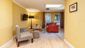 A living room with a sofa, armchair, floor lamp, and a small table. - Dragon Suites 1 Bed Luxury Apartment (Edinburgh)