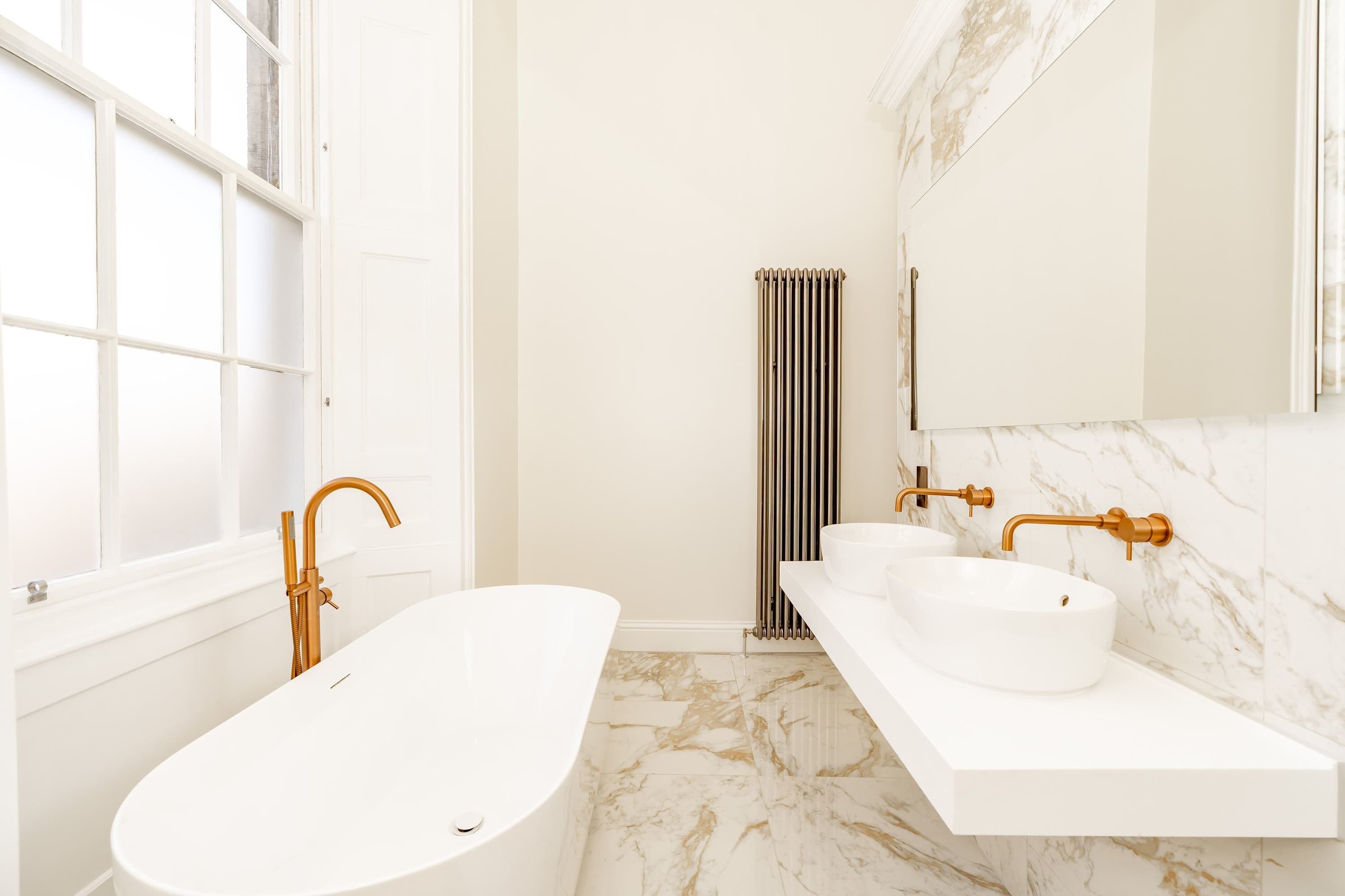 Une salle de bain moderne avec une baignoire sur pieds, un meuble-lavabo à deux vasques et un grand miroir.