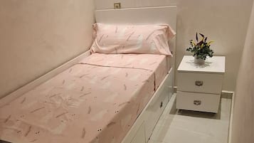 Ein kleines Schlafzimmer mit einem Bett, einem Nachttisch und einem Beistelltisch.