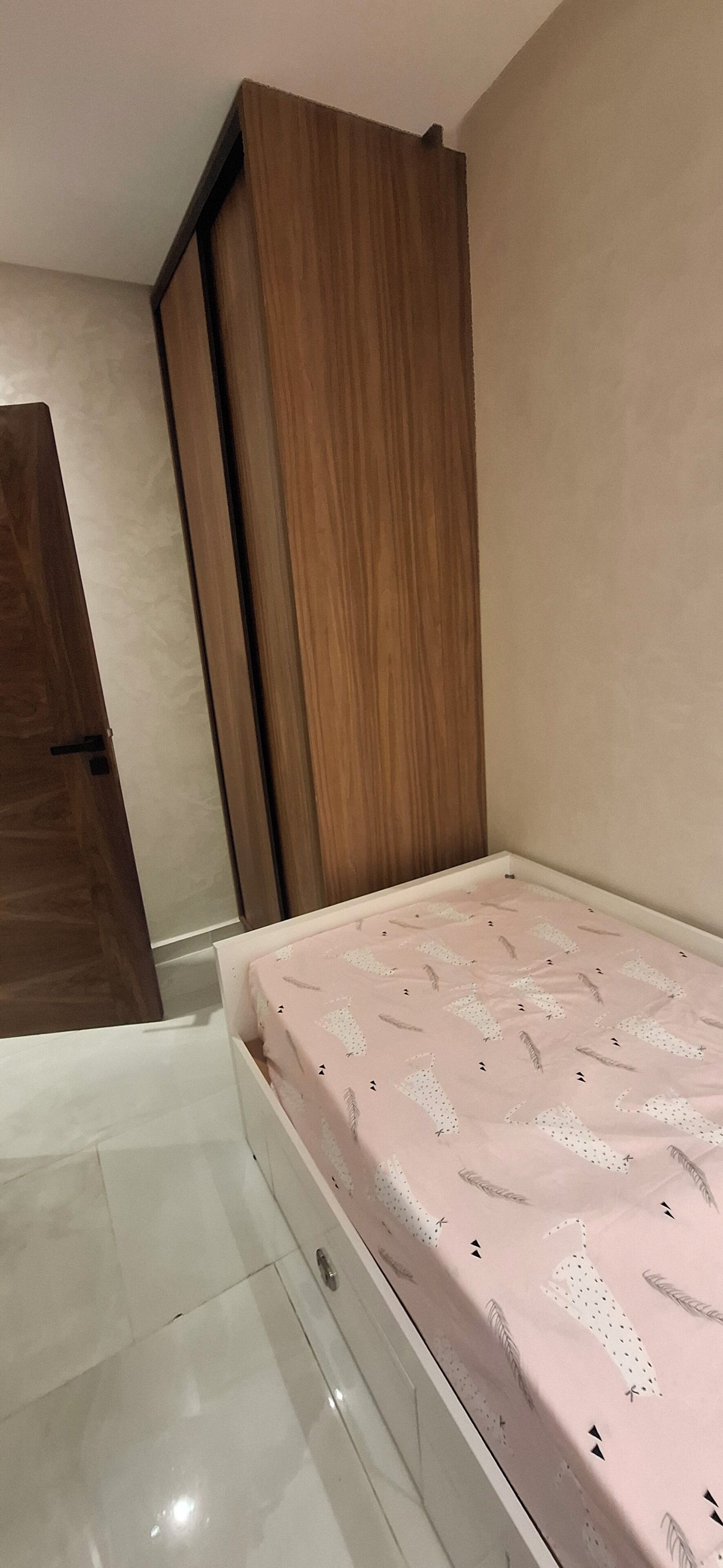 Ein Schlafzimmer mit einem Bett, einem Holzschrank und einer Tür.