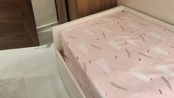 Ein Schlafzimmer mit einem Bett, einem Holzschrank und einer Tür.
