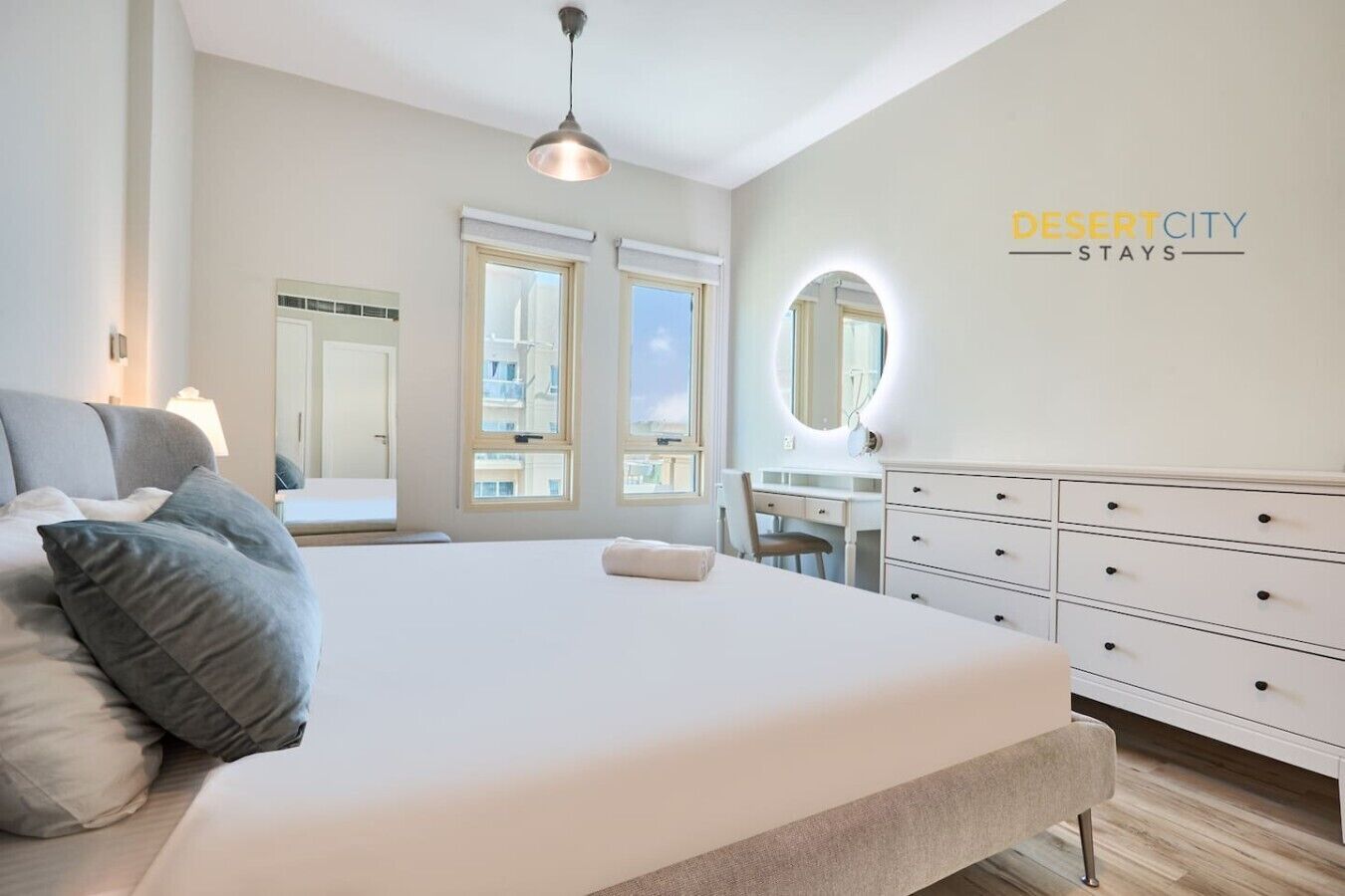 Une chambre moderne avec un grand lit, un bureau et une commode.