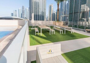 Eine Dachterrasse mit Pool, Sitzgelegenheiten und Blick auf die Stadtlandschaft.