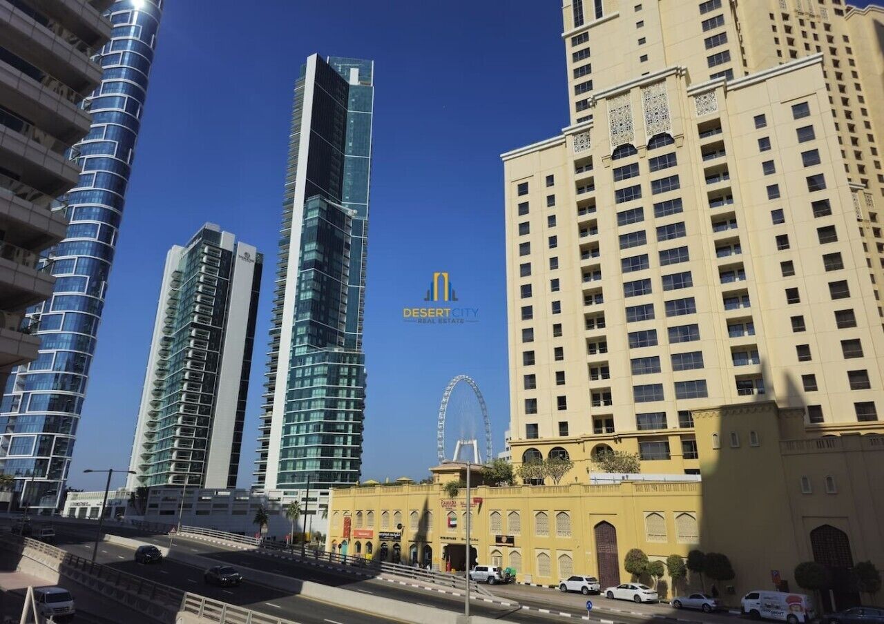 Un paisaje urbano con modernos rascacielos, una destacada noria y un edificio histórico con ventanas de arco.