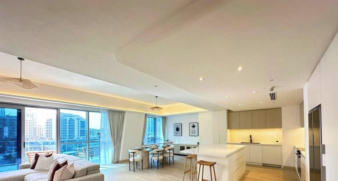Een modern appartement met een eetgedeelte, keuken en een groot raam met uitzicht op de stad.