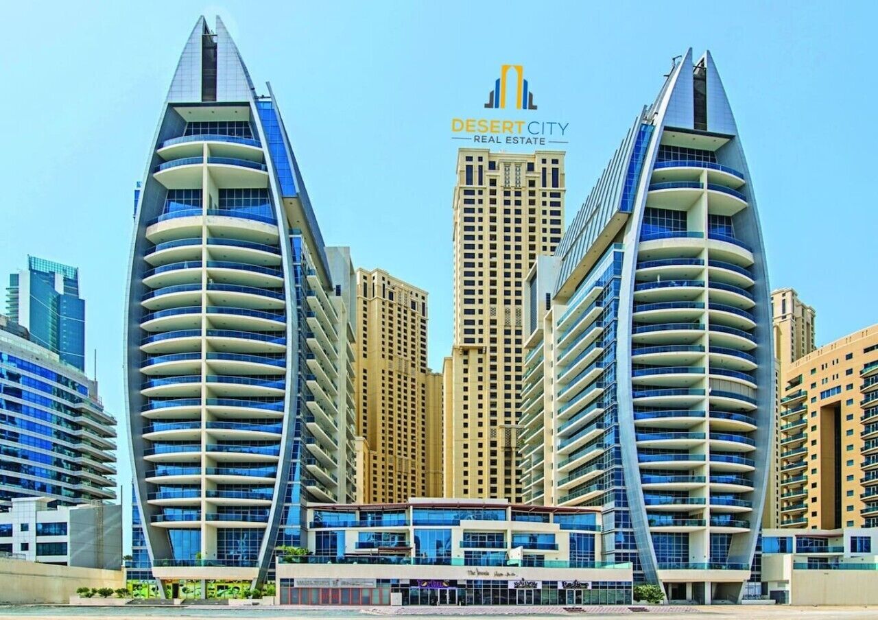 Un hôtel moderne doté d’une façade incurvée originale, de nombreux balcons et offrant une vue dégagée sur les immeubles environnants.