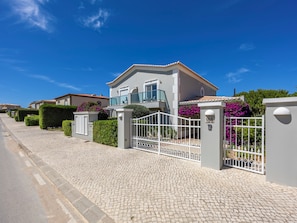 A residential property with a paved driveway, a gated entrance, and a well-maintained garden. - Boavista - Golf View Villa (Lagos)