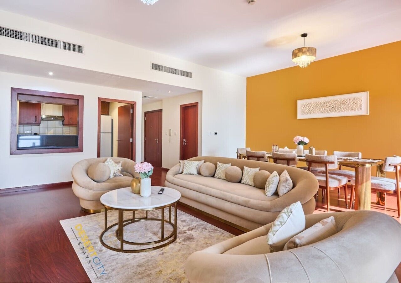 Una sala de estar moderna con un conjunto de sofás, una mesa de centro y un comedor con sillas y una mesa.